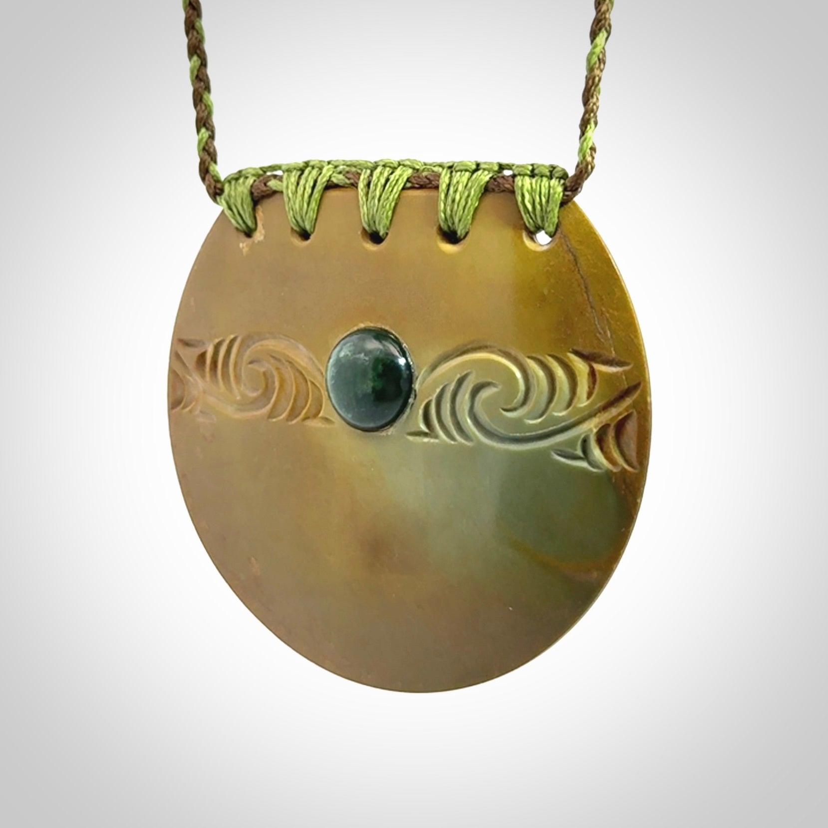 Hand carved New Zealand Flower Jade half-shield with whakarei design pendant.