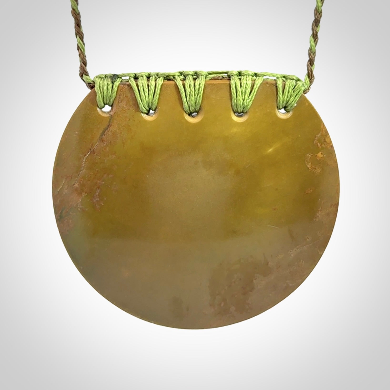 Hand carved New Zealand Flower Jade half-shield with whakarei design pendant.