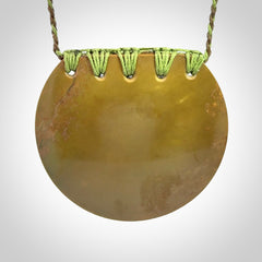 Hand carved New Zealand Flower Jade half-shield with whakarei design pendant.