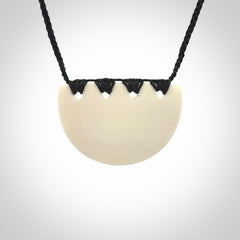 Hand carved bone breastplate pendant.