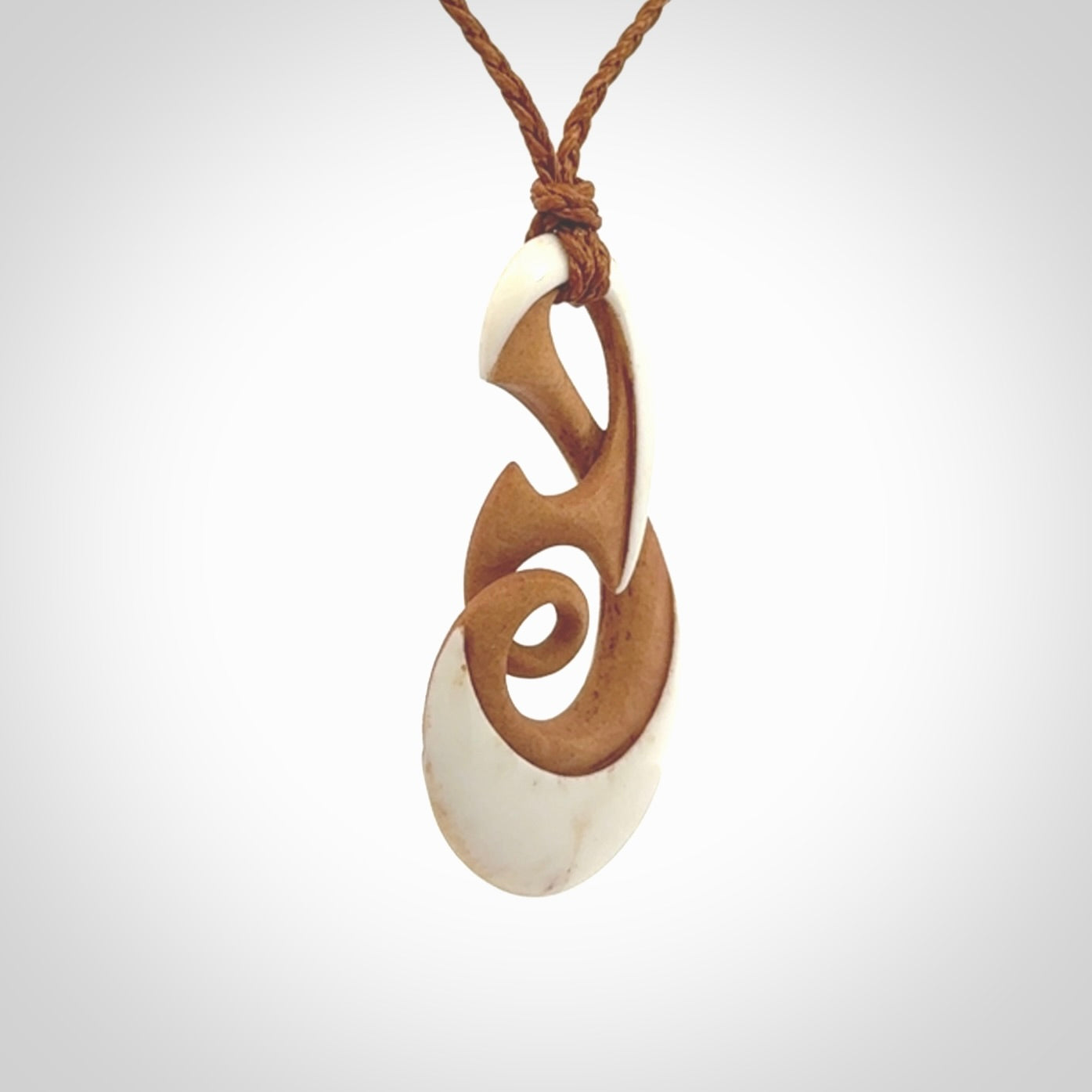 A hand carved bone contemporary, intricate twist pendant. The cord is a gingernut brown colour and is a adjustable.