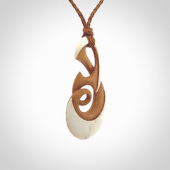 A hand carved bone contemporary, intricate twist pendant. The cord is a gingernut brown colour and is a adjustable.