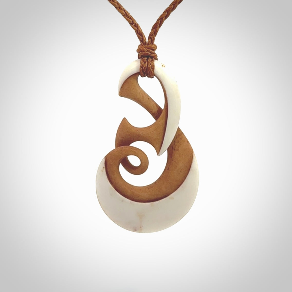 A hand carved bone contemporary, intricate twist pendant. The cord is a gingernut brown colour and is a adjustable.