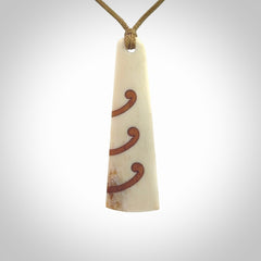 A hand carved, double sided, bone toki with triple koru, intricate pendant. The cord is a black colour and is adjustable.