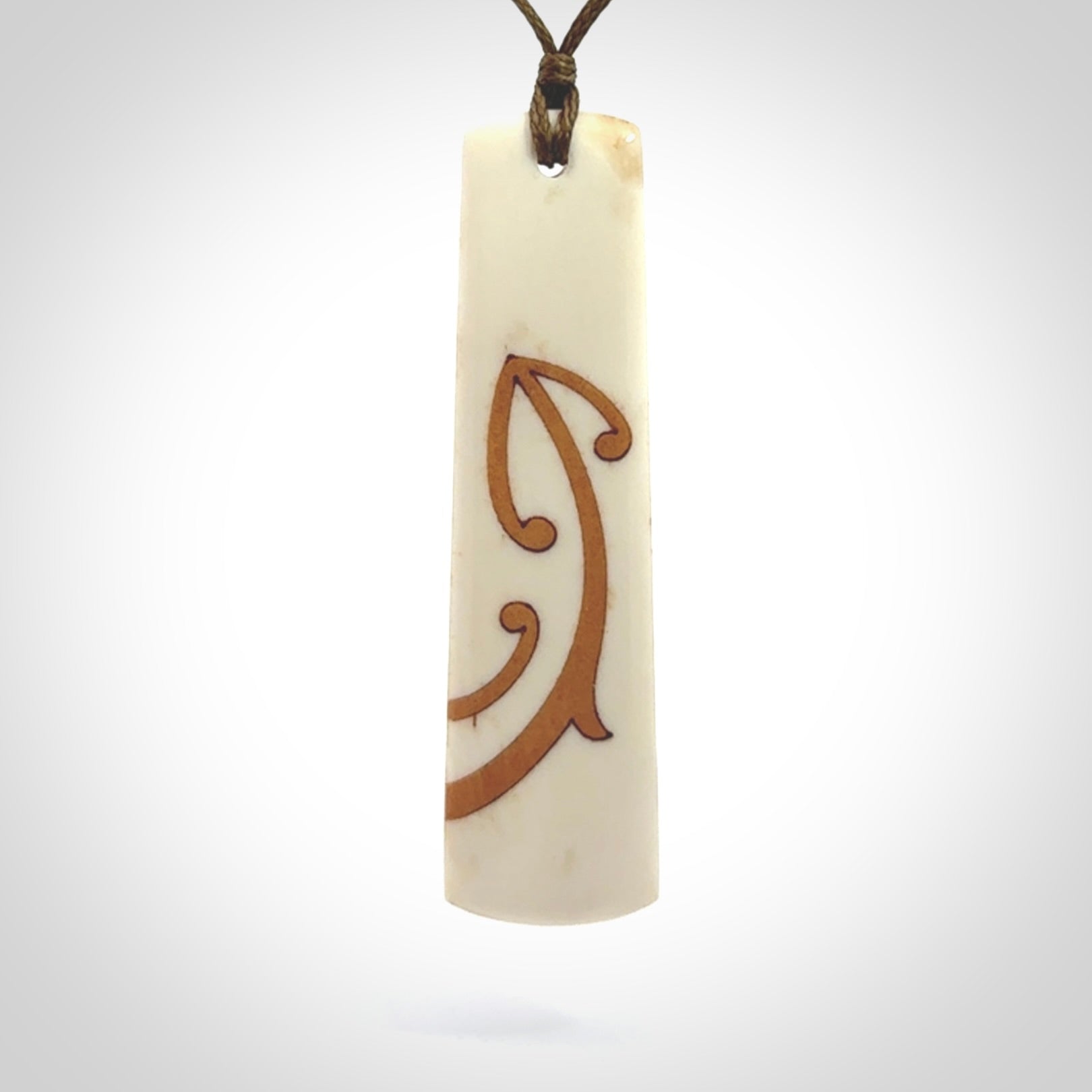 A hand carved, double sided, bone toki with triple koru, intricate pendant. The cord is a marrakesh colour and is adjustable.