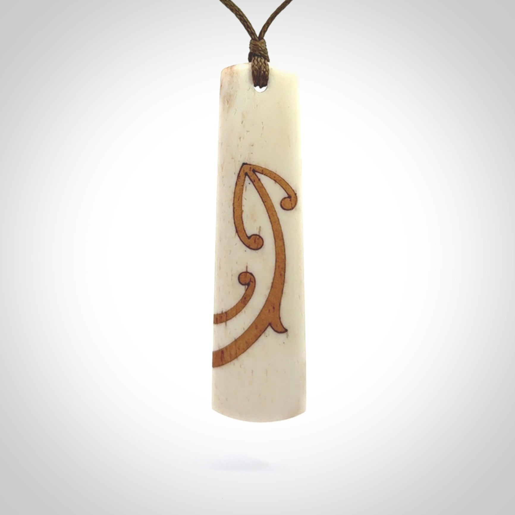 A hand carved, double sided, bone toki with triple koru, intricate pendant. The cord is a marrakesh colour and is adjustable.