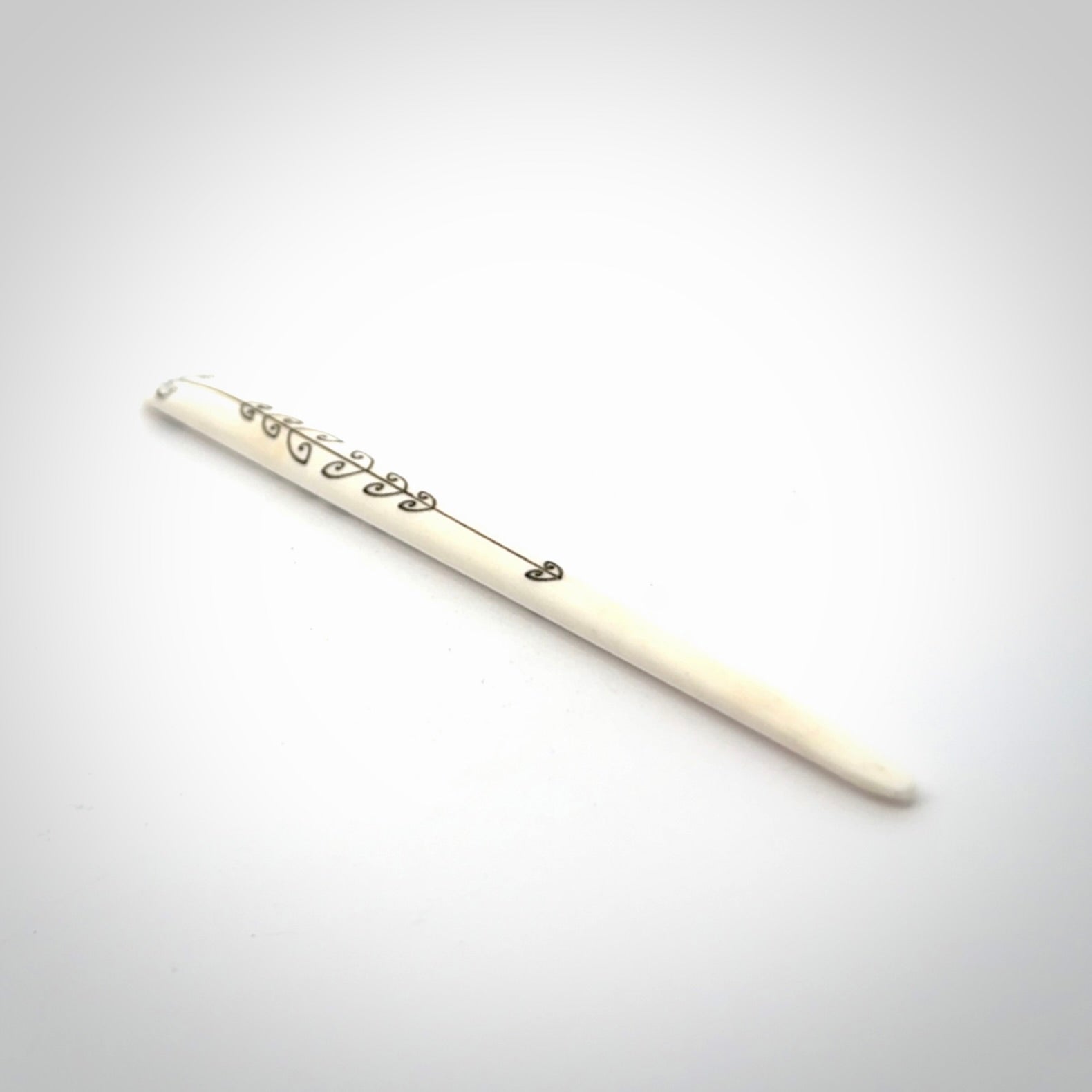 Hand carved bone hair pin with double sided koru design.