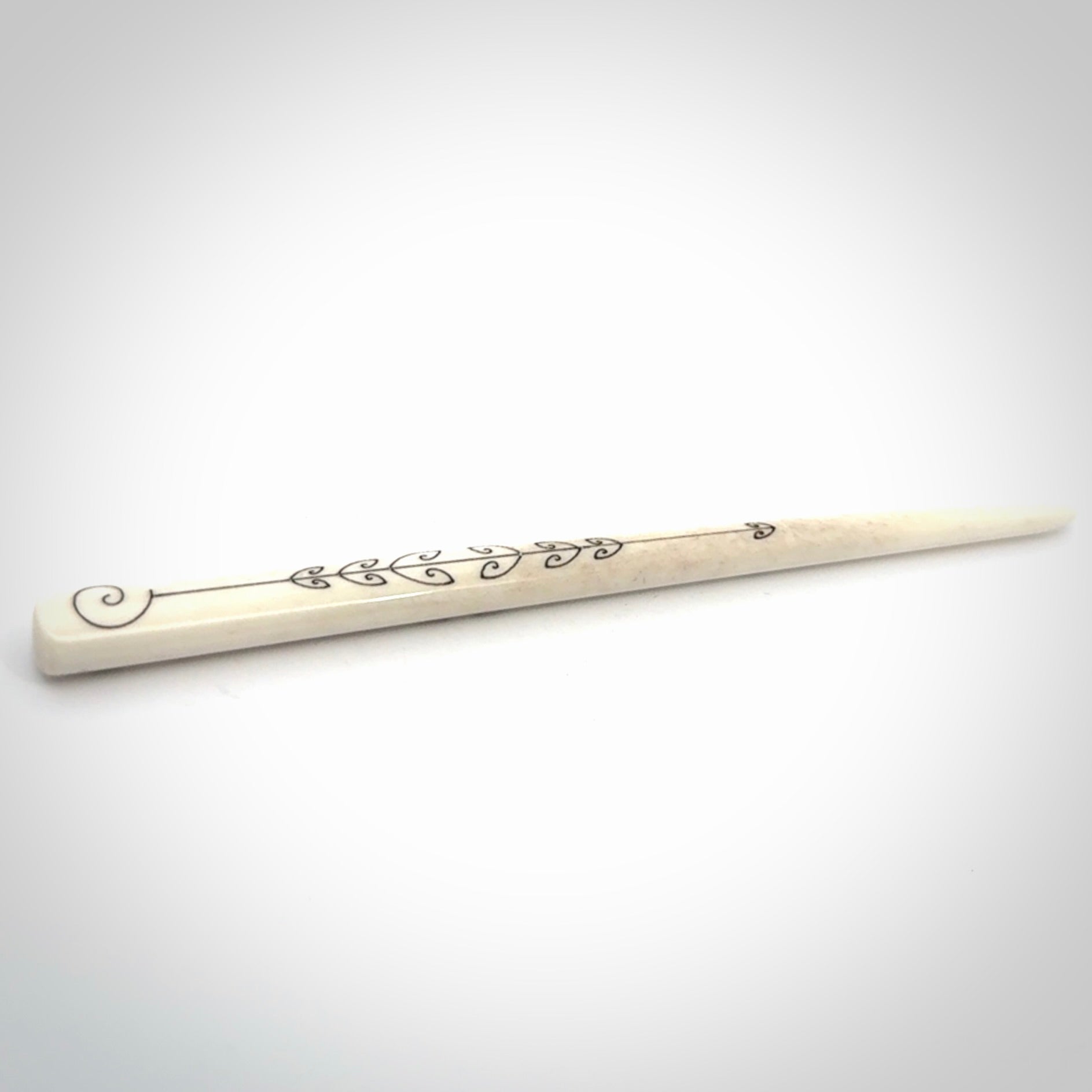 Hand carved bone hair pin with double sided koru design.
