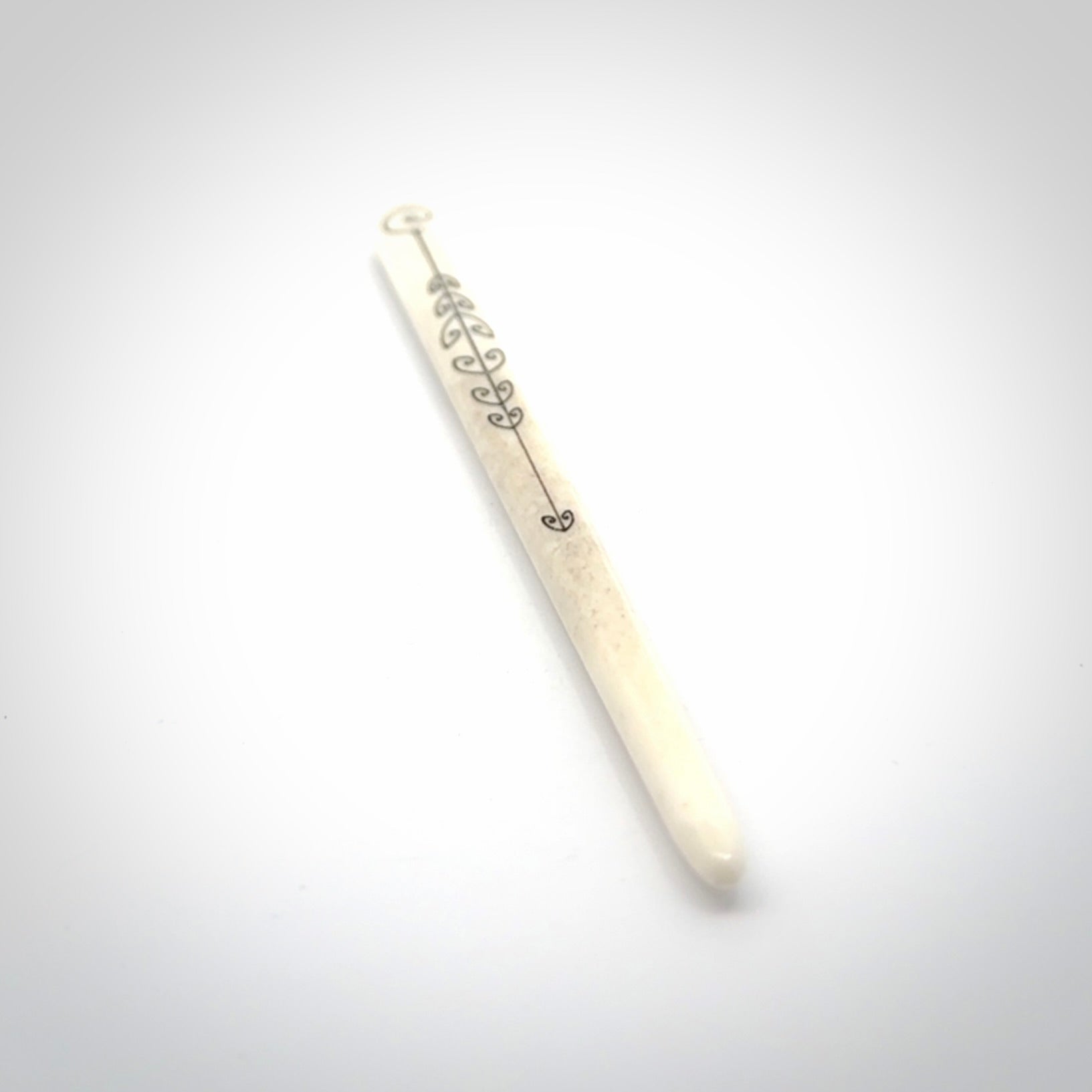 Hand carved bone hair pin with double sided koru design.