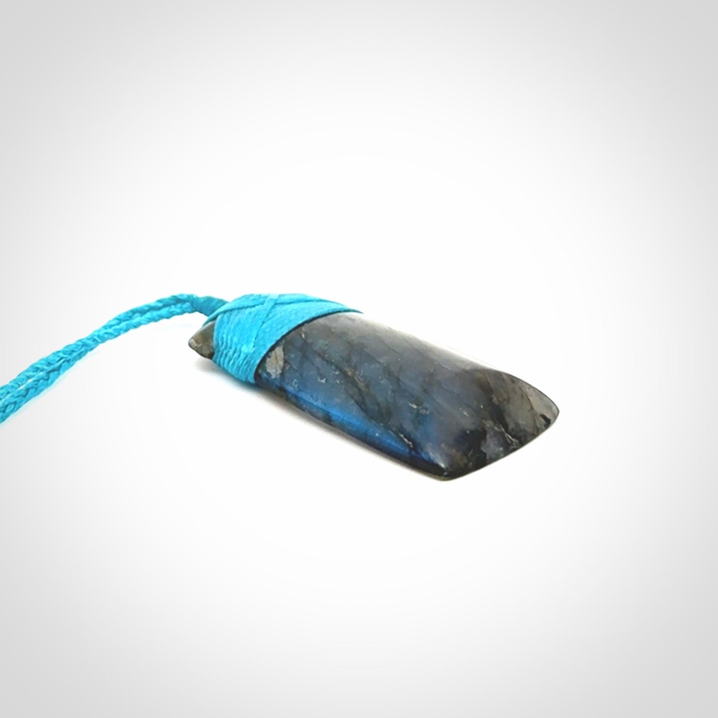 This picture shows a Labradorite stone toki pendant that we have hand carved.