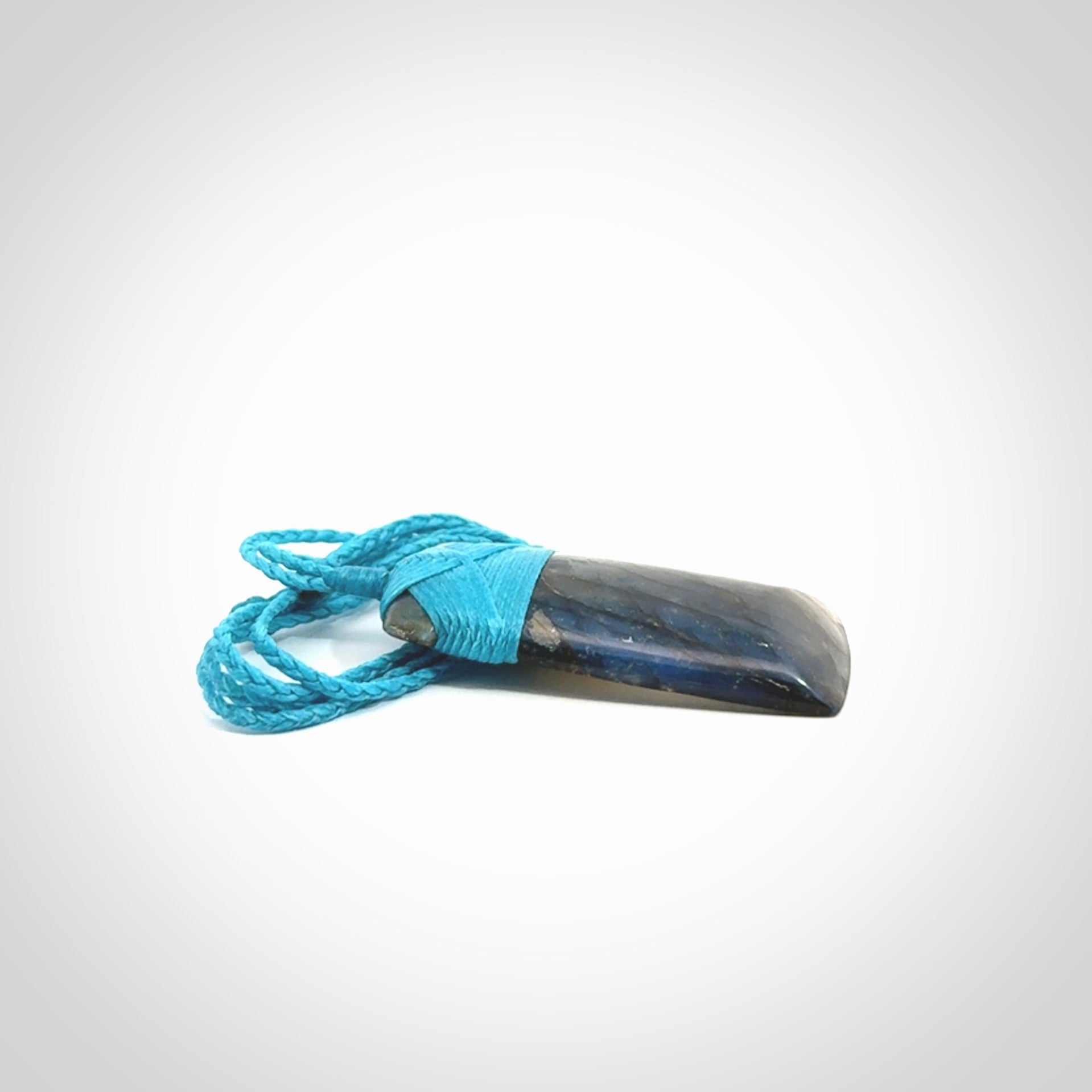This picture shows a Labradorite stone toki pendant that we have hand carved.