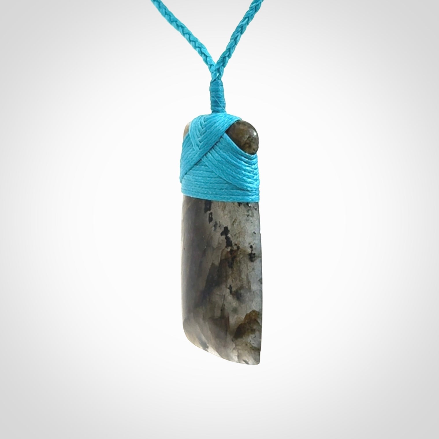 This picture shows a Labradorite stone toki pendant that we have hand carved.