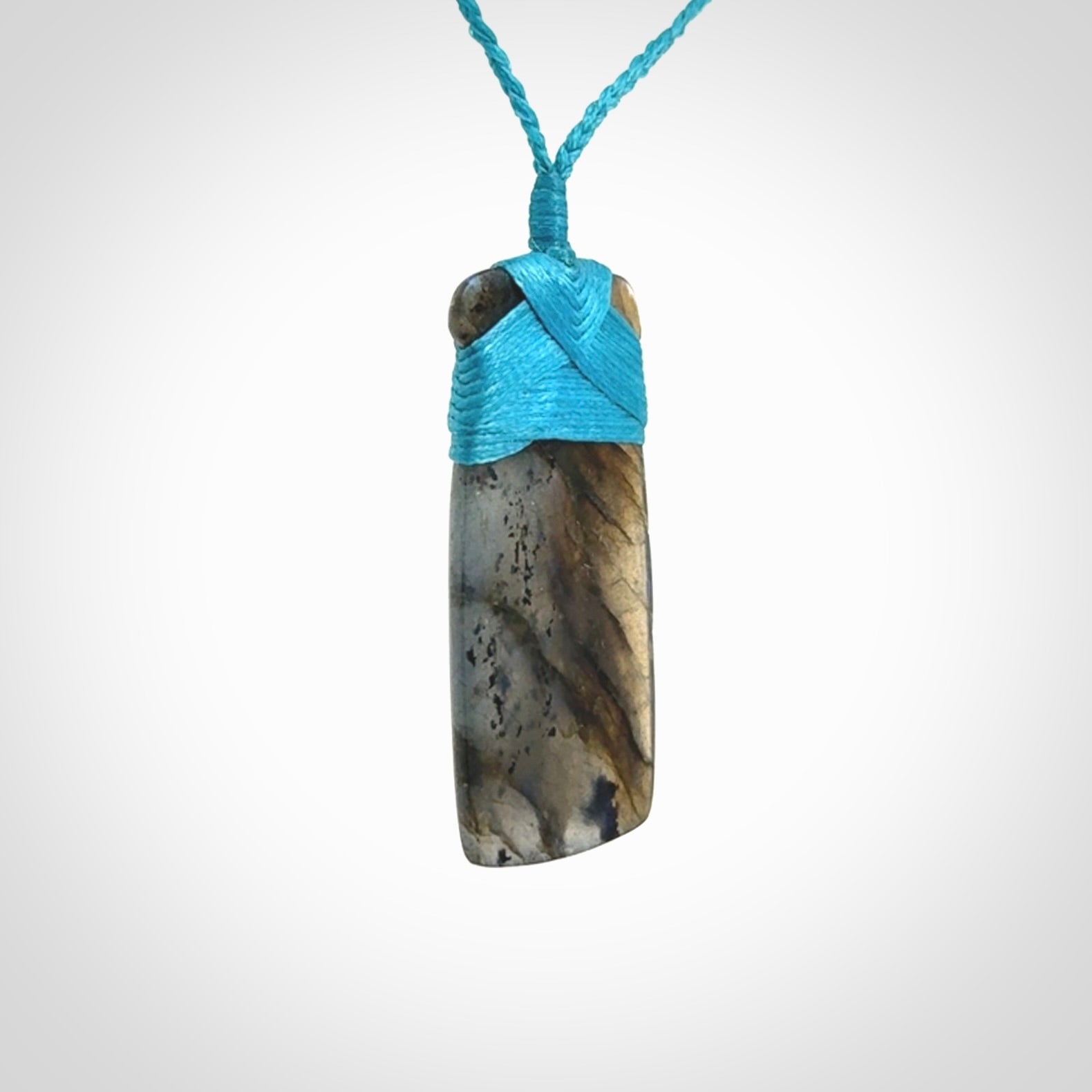 This picture shows a Labradorite stone toki pendant that we have hand carved.