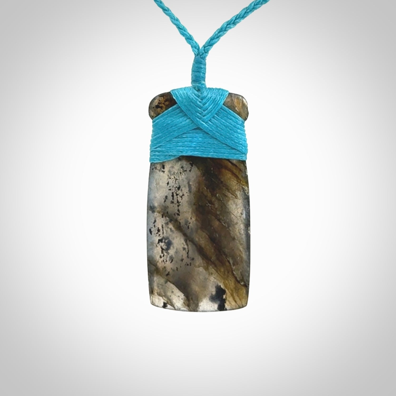 This picture shows a Labradorite stone toki pendant that we have hand carved.