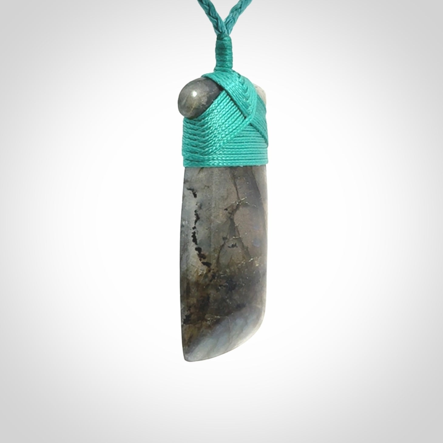 This picture shows a Labradorite stone toki pendant that we have hand carved.