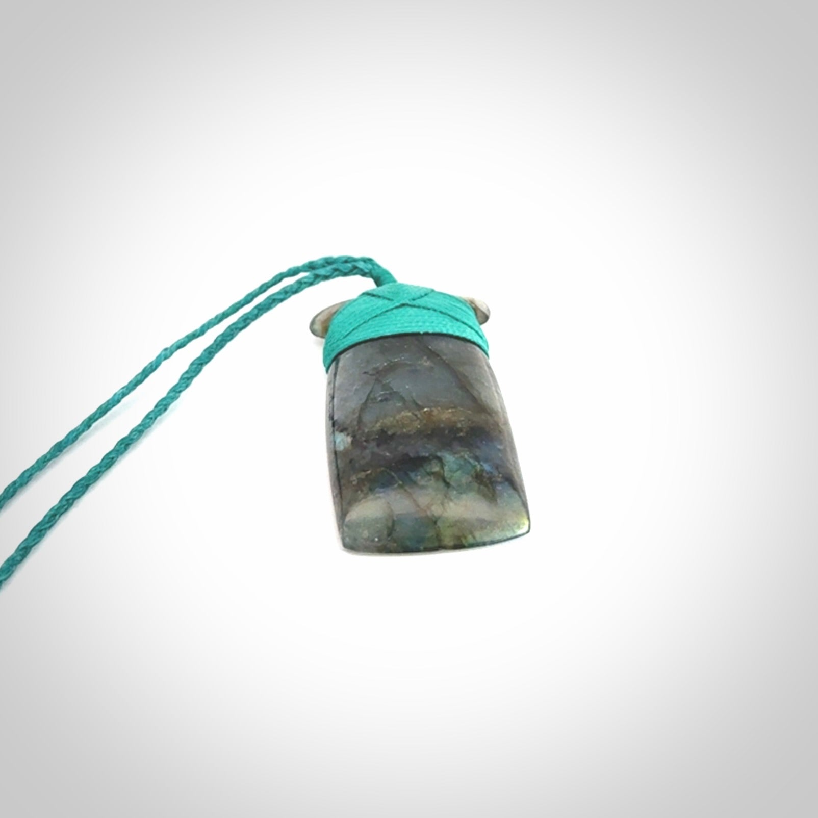 This picture shows a Labradorite stone toki pendant that we have hand carved.