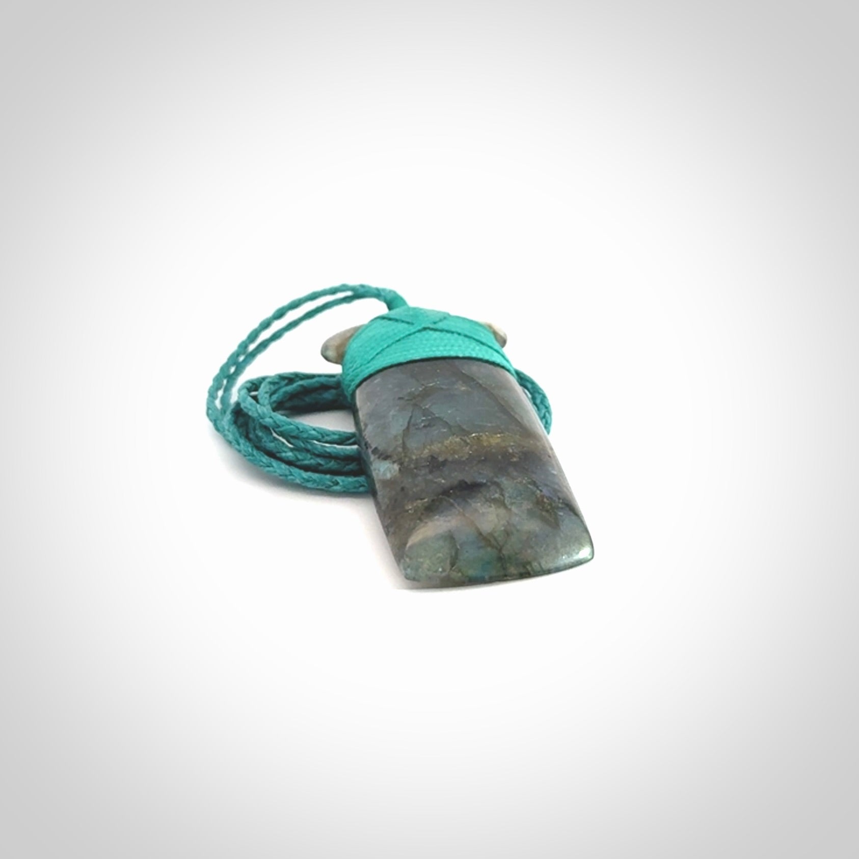 This picture shows a Labradorite stone toki pendant that we have hand carved.