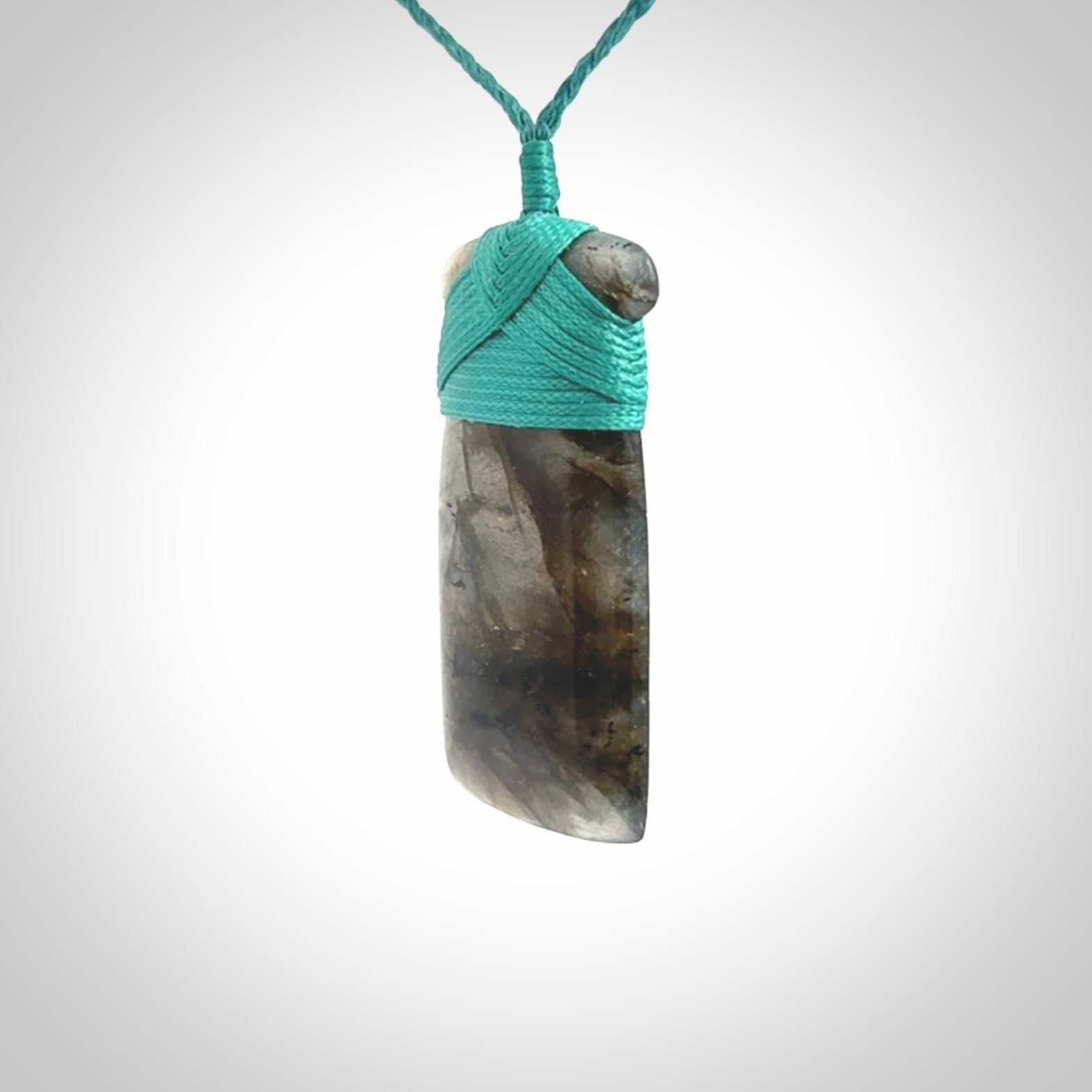 This picture shows a Labradorite stone toki pendant that we have hand carved.