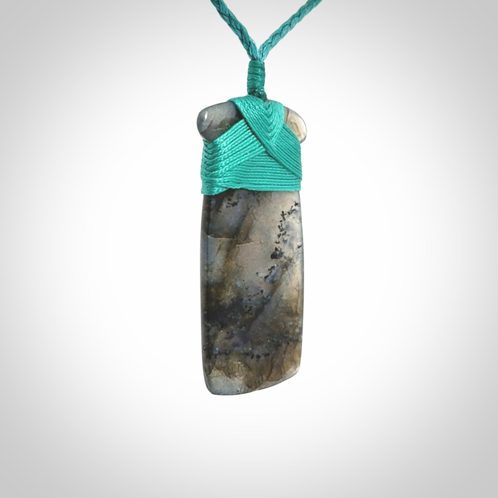 This picture shows a Labradorite stone toki pendant that we have hand carved.