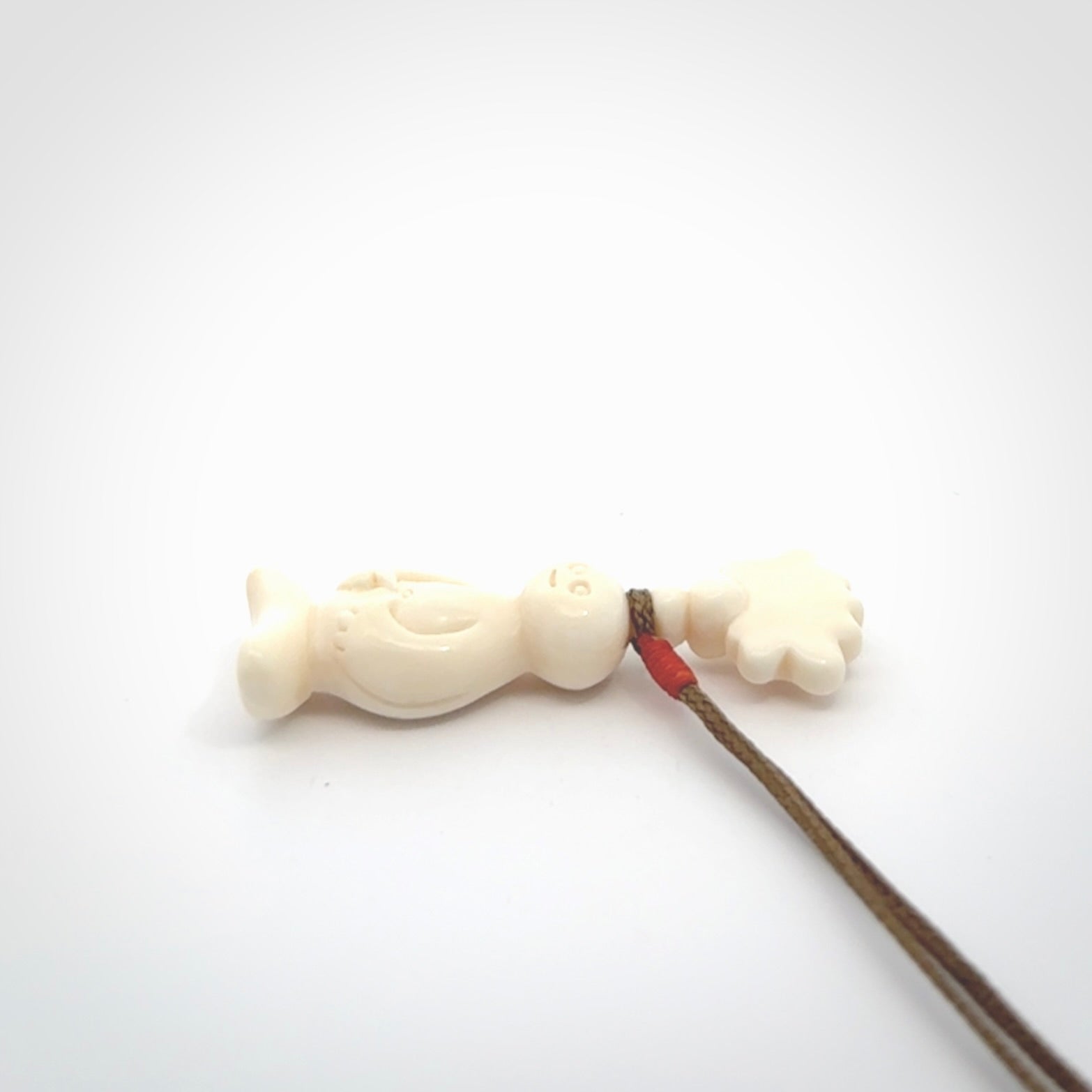 This is a hand carved bone daydreaming character pendant. This is a small-medium sized necklace with adjustable cord.