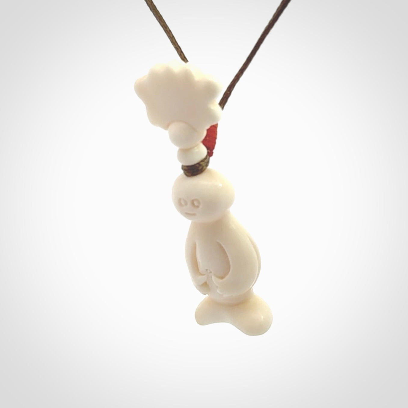 This is a hand carved bone daydreaming character pendant. This is a small-medium sized necklace with adjustable cord.