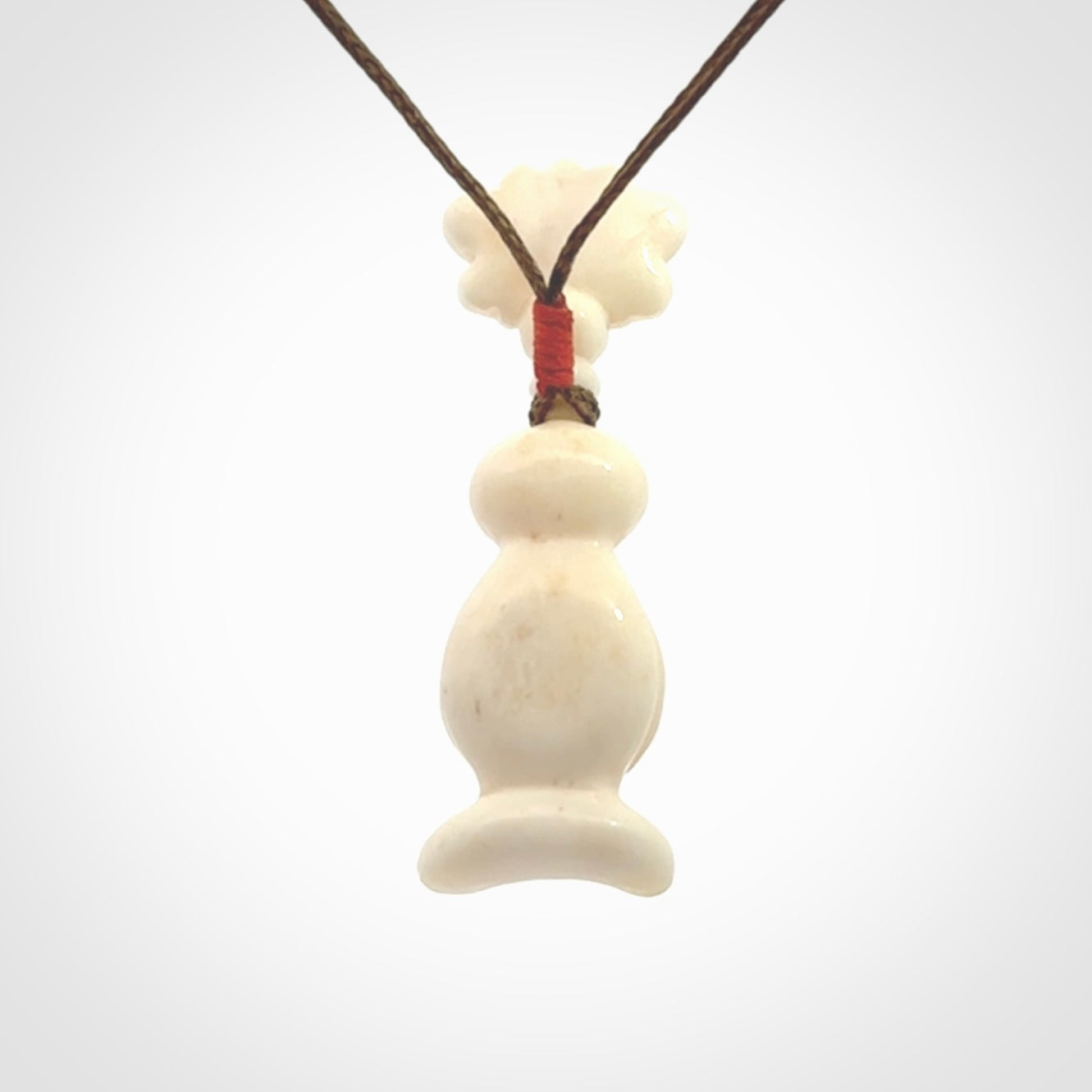 This is a hand carved bone daydreaming character pendant. This is a small-medium sized necklace with adjustable cord.