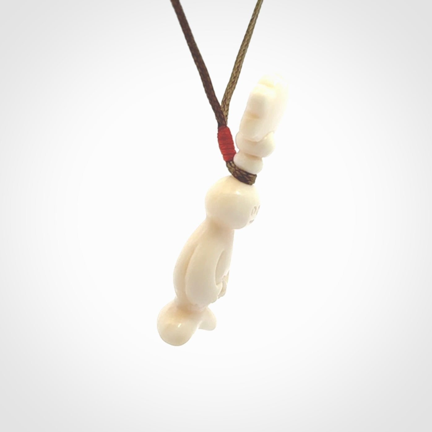 This is a hand carved bone daydreaming character pendant. This is a small-medium sized necklace with adjustable cord.
