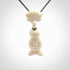 This is a hand carved bone daydreaming character pendant. This is a small-medium sized necklace with adjustable cord.