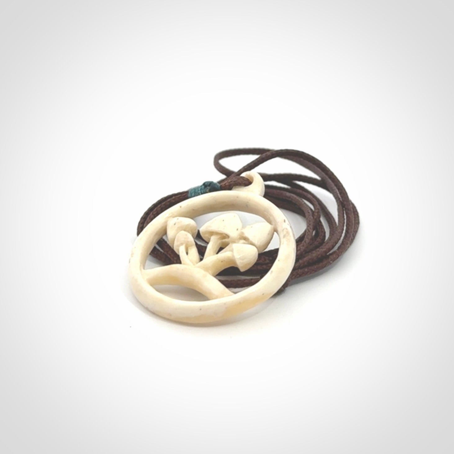 This is a hand carved bone mushroom pendant. This is a smaller sized necklace with adjustable cord.