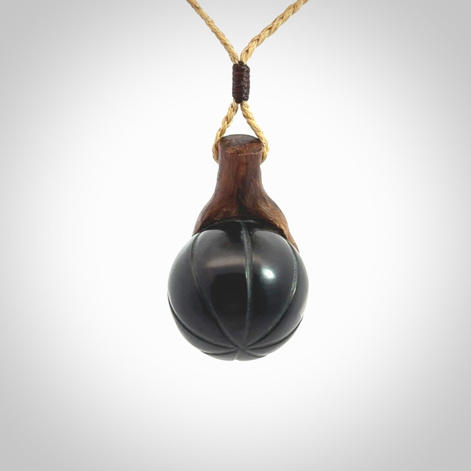 This is a very cool pendant that we've had carved for all you Basketball fans. This is a pendant with a wooden hand holding a black jade basketball. We provide this on an adjustable cord, and we ship worldwide