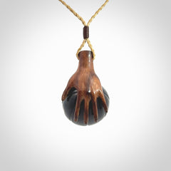 This is a very cool pendant that we've had carved for all you Basketball fans. This is a pendant with a wooden hand holding a black jade basketball. We provide this on an adjustable cord, and we ship worldwide