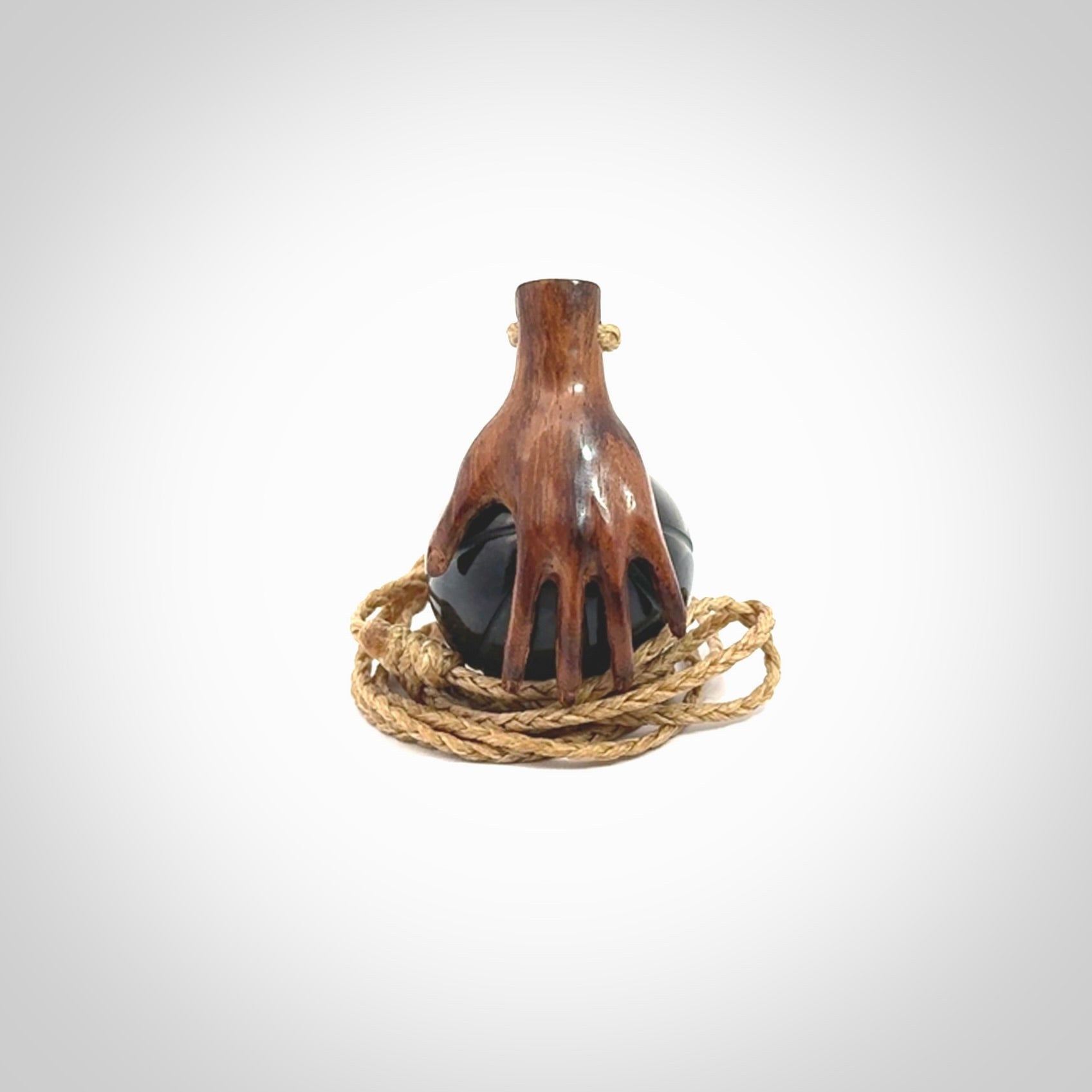This is a very cool pendant that we've had carved for all you Basketball fans. This is a pendant with a wooden hand holding a black jade basketball. We provide this on an adjustable cord, and we ship worldwide