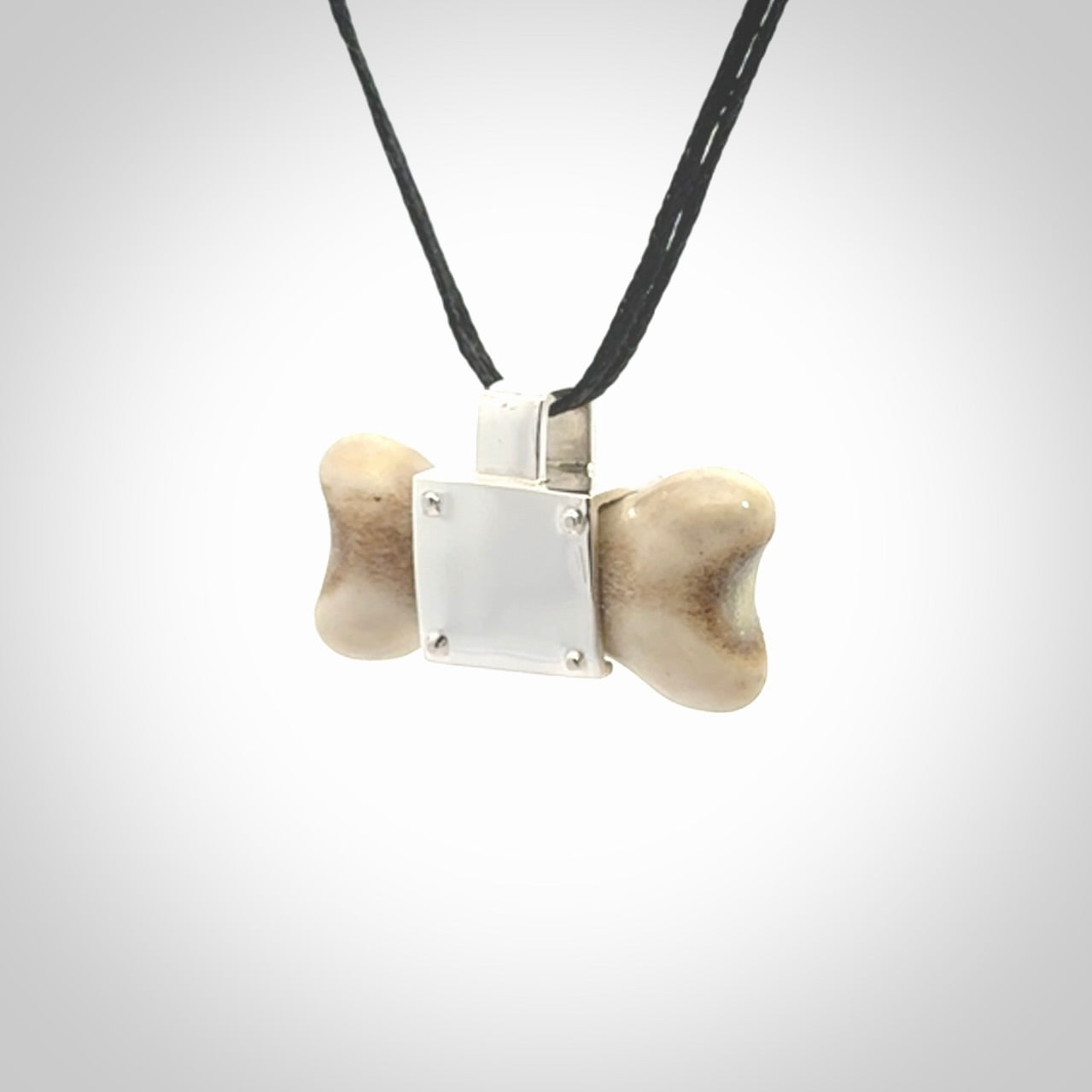 This is a hand carved deer antler dog bone dog tag. It is made from deer antler, bone and sterling silver. Hand made dog tags for your dog.