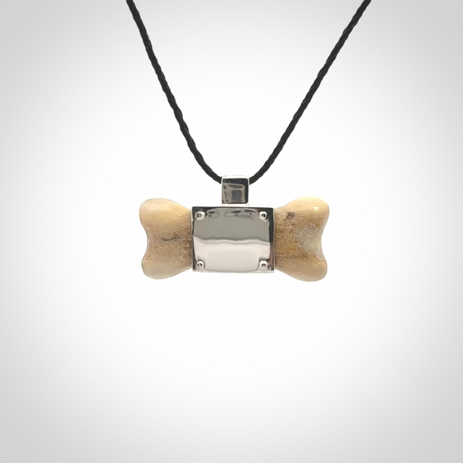 This is a hand carved deer antler dog bone dog tag. It is made from deer antler, bone and sterling silver. Hand made dog tags for your dog.