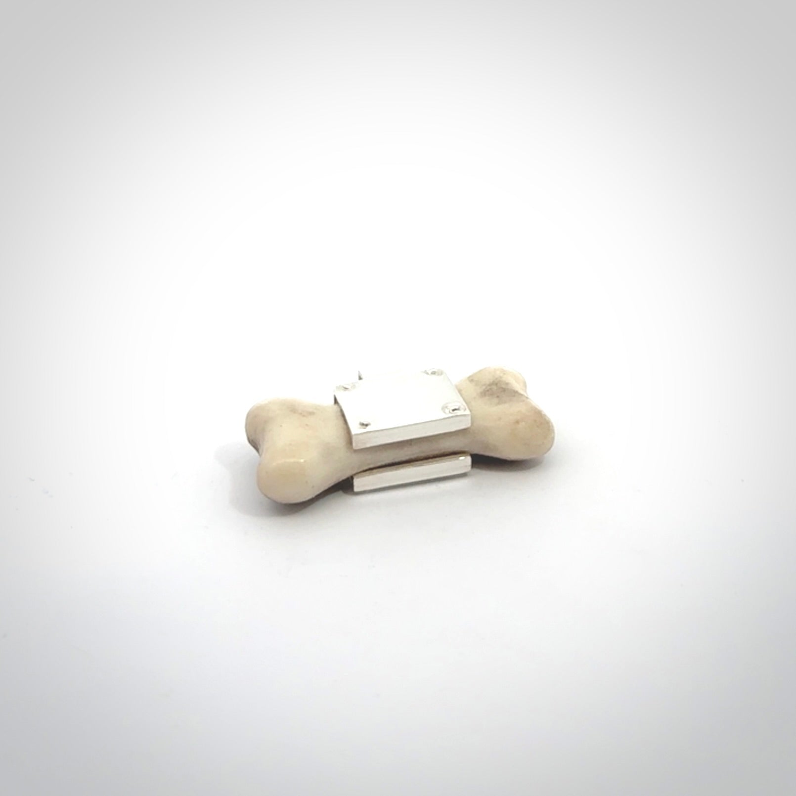 This is a hand carved deer antler dog bone dog tag. It is made from deer antler, bone and sterling silver. Hand made dog tags for your dog.