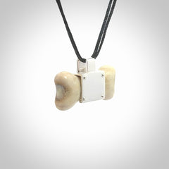 This is a hand carved deer antler dog bone dog tag. It is made from deer antler, bone and sterling silver. Hand made dog tags for your dog.