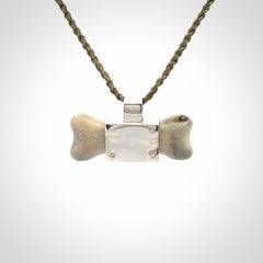 This is a hand carved deer antler dog bone dog tag. It is made from deer antler, bone and sterling silver. Hand made dog tags for your dog.