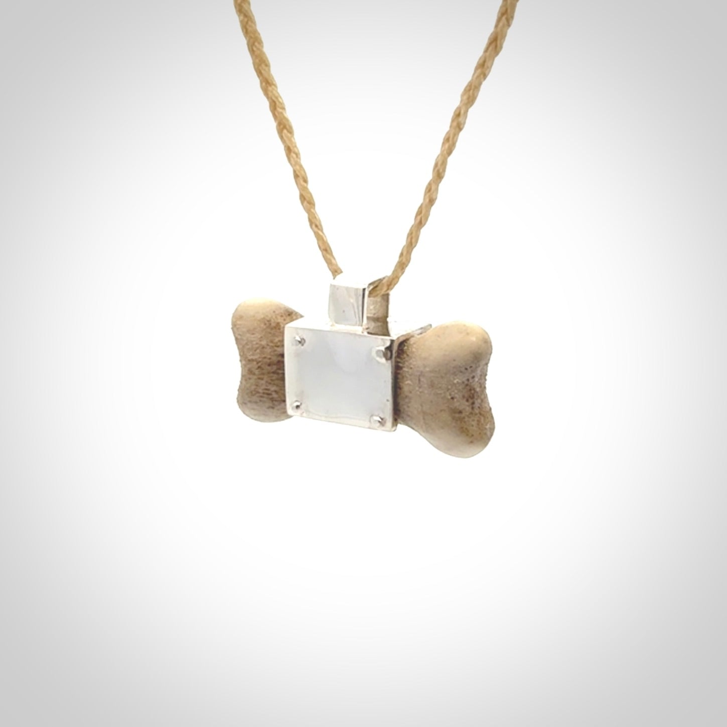 This is a hand carved deer antler dog bone dog tag. It is made from deer antler, bone and sterling silver. Hand made dog tags for your dog.