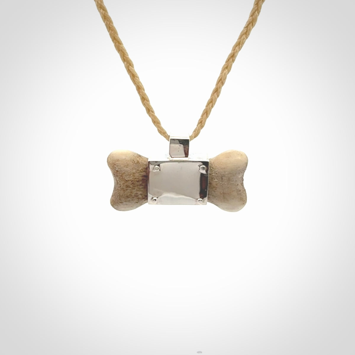 This is a hand carved deer antler dog bone dog tag. It is made from deer antler, bone and sterling silver. Hand made dog tags for your dog.