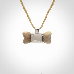 This is a hand carved deer antler dog bone dog tag. It is made from deer antler, bone and sterling silver. Hand made dog tags for your dog.