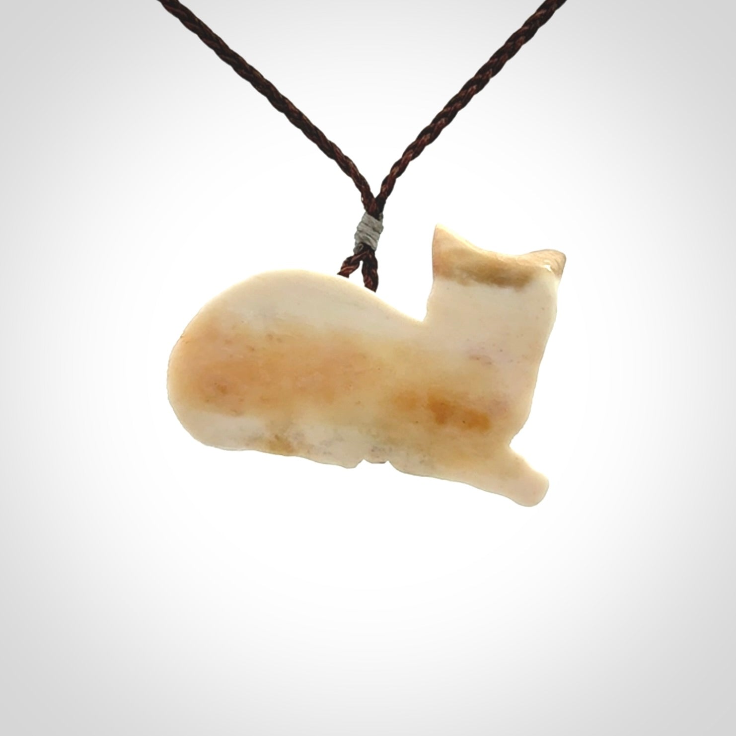 This cat pendant radiates quiet elegance with a regal composure. Hand made in bone.