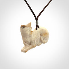 This cat pendant radiates quiet elegance with a regal composure. Hand made in bone.