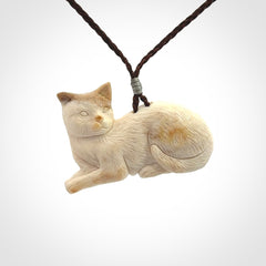 This cat pendant radiates quiet elegance with a regal composure. Hand made in bone.