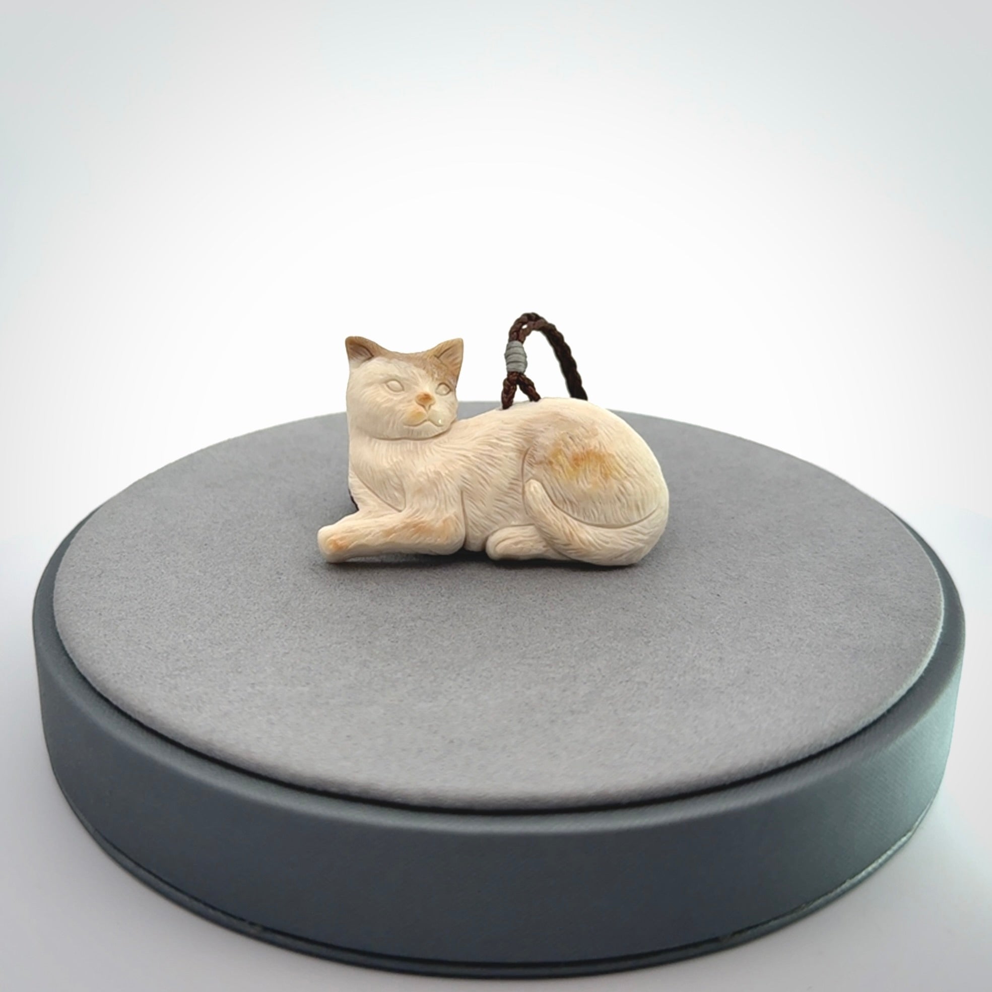 This cat pendant radiates quiet elegance with a regal composure. Hand made in bone.