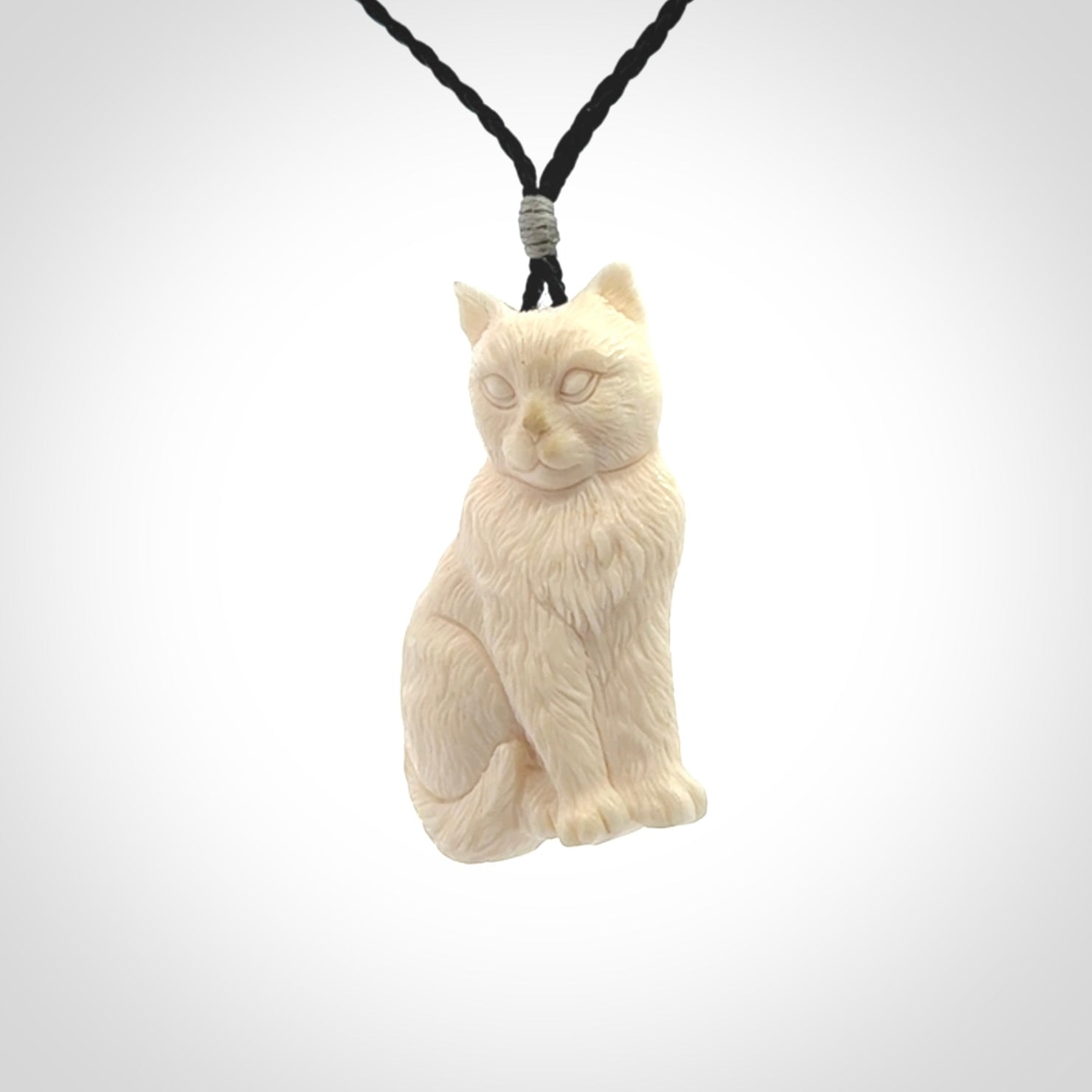 A charismatic cat pendant, hand carved in bone