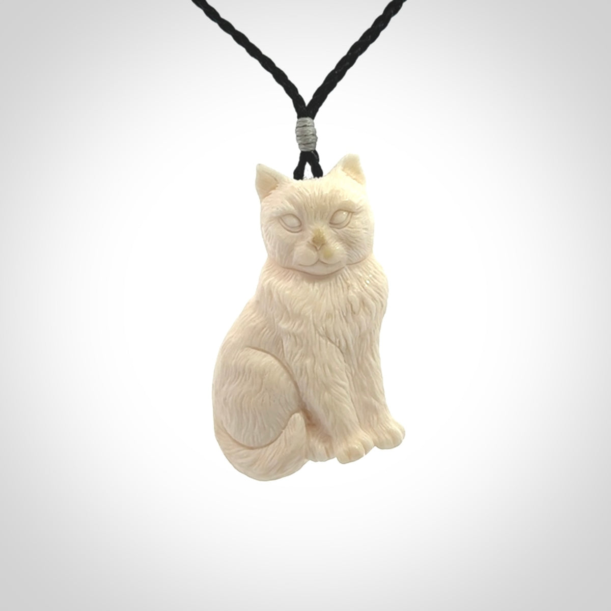 A charismatic cat pendant, hand carved in bone