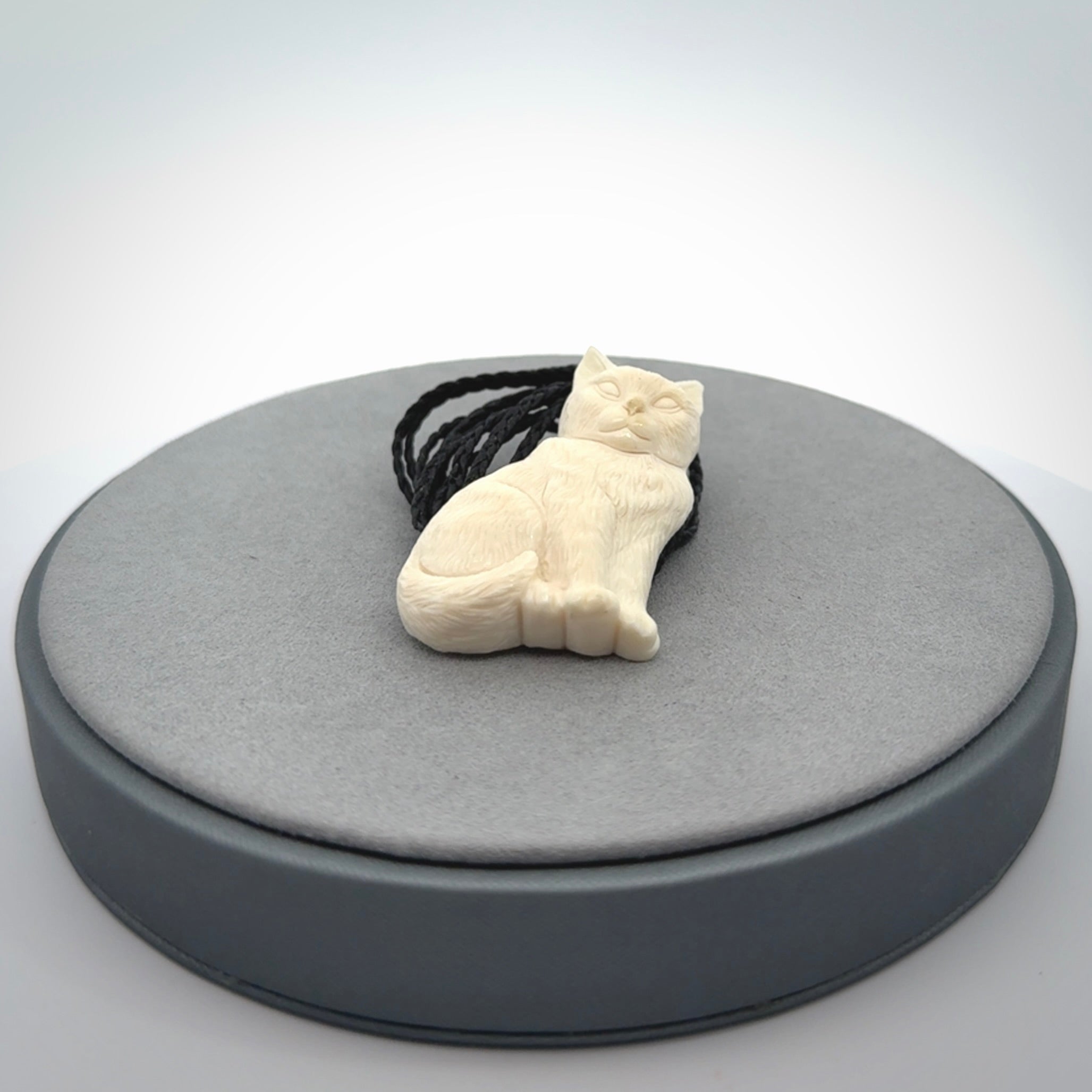 A charismatic cat pendant, hand carved in bone