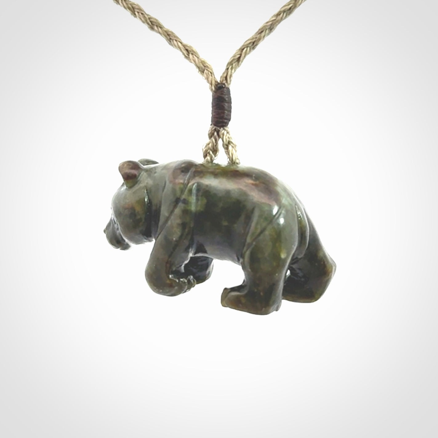 This picture shows a pendant that we designed in New Zealand jade. It is a little green bear that has a walking stance and is carved in detail. A really attractive and eye-catching piece of handmade jewellery. The cord is hand plaited braid and the length can be adjusted.
