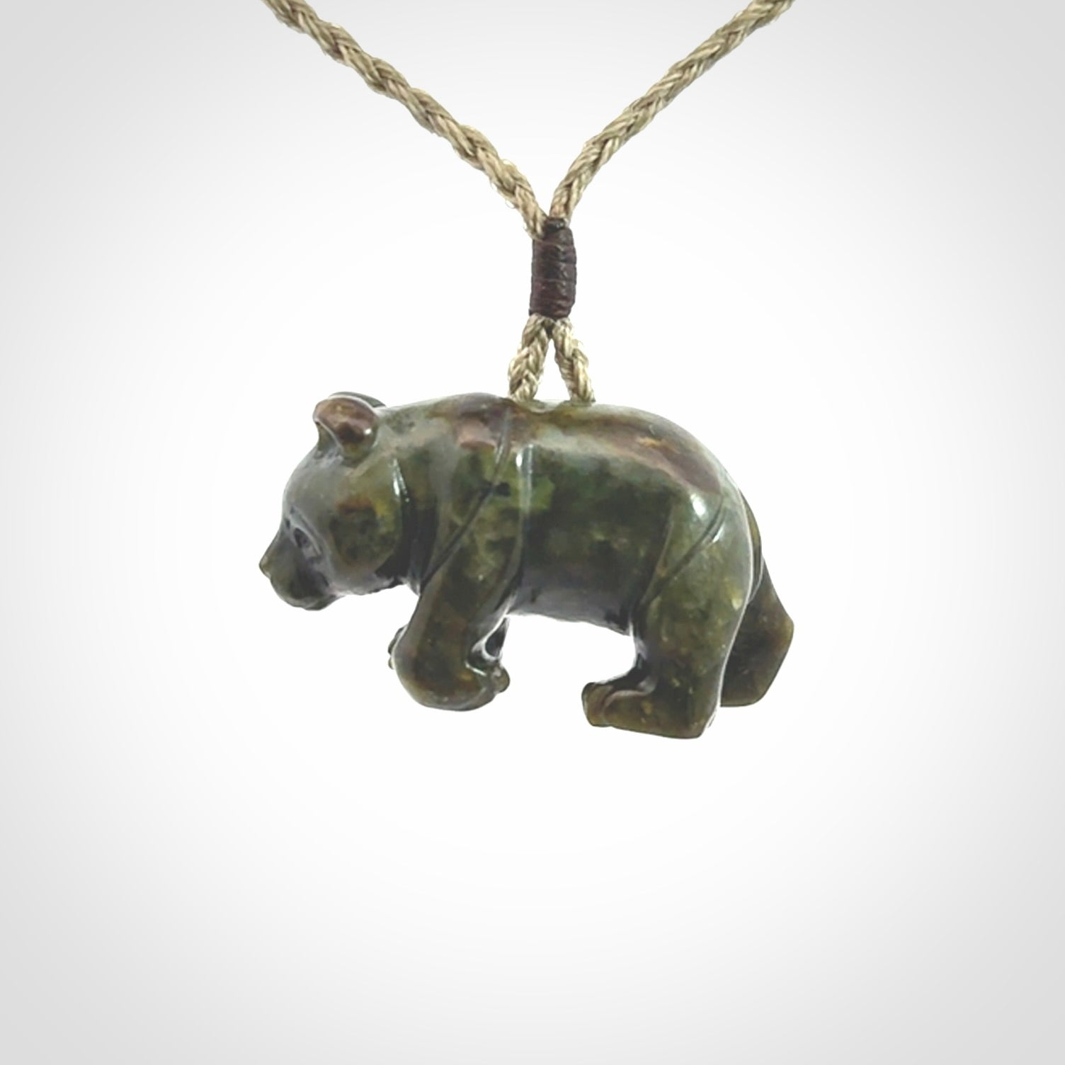 This picture shows a pendant that we designed in New Zealand jade. It is a little green bear that has a walking stance and is carved in detail. A really attractive and eye-catching piece of handmade jewellery. The cord is hand plaited braid and the length can be adjusted.