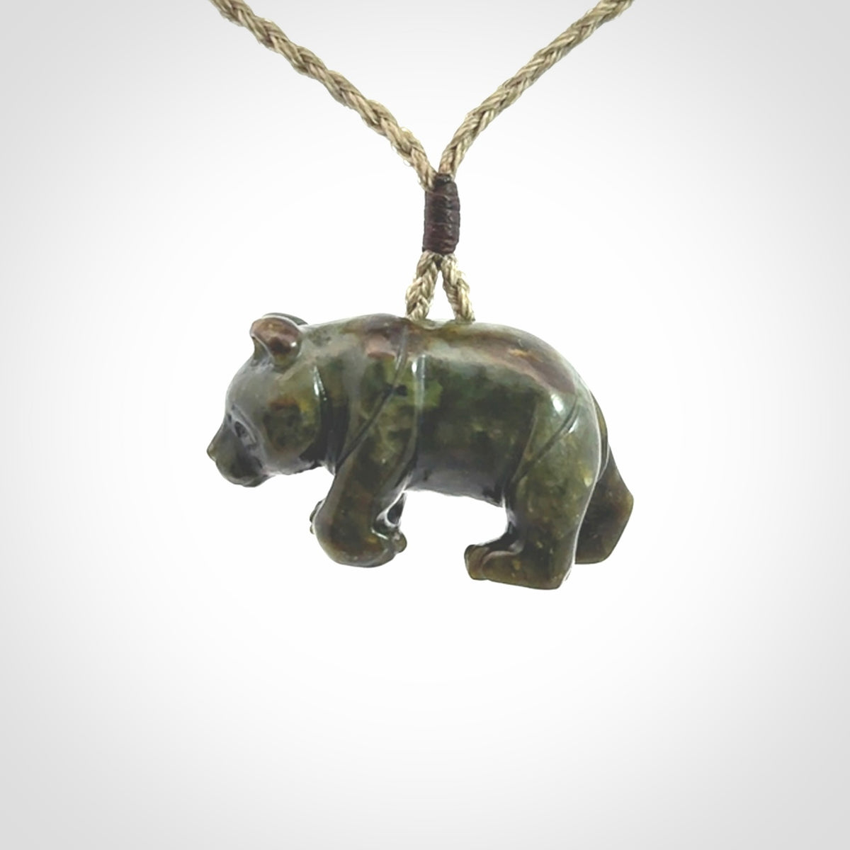 This picture shows a pendant that we designed in New Zealand jade. It is a little green bear that has a walking stance and is carved in detail. A really attractive and eye-catching piece of handmade jewellery. The cord is hand plaited braid and the length can be adjusted.